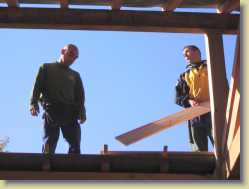 The two carpenters working on the fascia of the roof light projection.