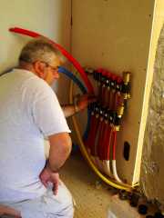 Michel fixing the distribution connection for the underfloor heating.  There are 5 circuits each with taps and balancing valve.